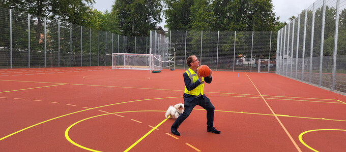 Bürgermeister Müller mit einem Basketball in der Hand auf dem neuen Allwetterplatz | © Stadt Geretsried