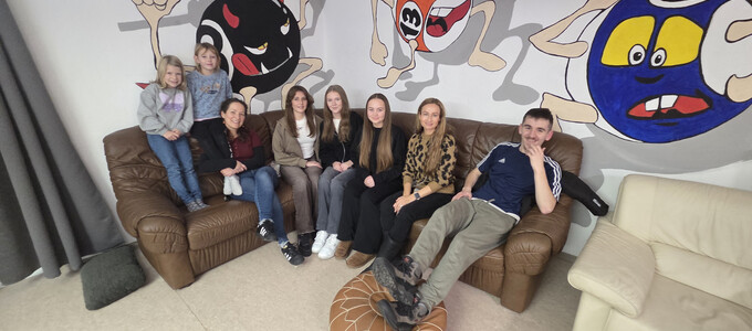 Team und Kinder sitzen auf einer Couch im Jugendtreff Ein-Stein | © Stadt Geretsried