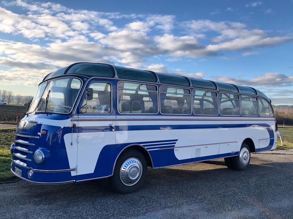 blau-weißer Oldtimer-Bus auf der Straße | © Sittenauer-Reisen