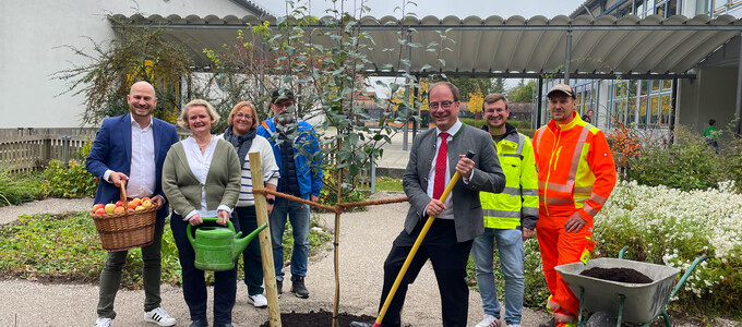 Gruppe steht im Garten der Schule neben Baum | © Stadt Geretsried