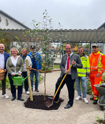 Gruppe steht im Garten der Schule neben Baum | © Stadt Geretsried