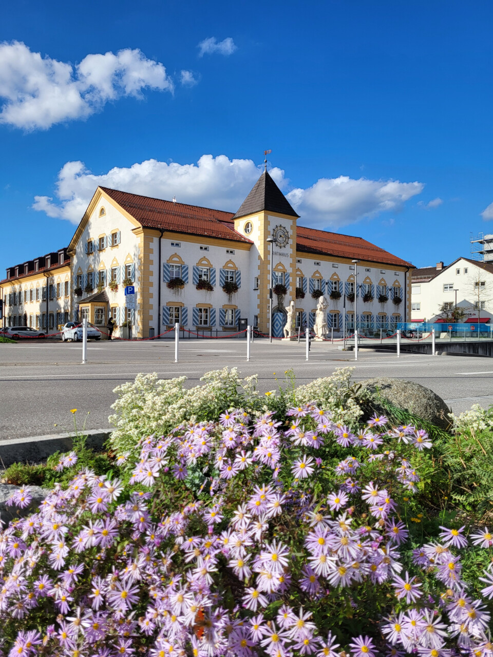 Außenansicht vom Rathaus mit lila Blumen davor | © Stadt Geretsried