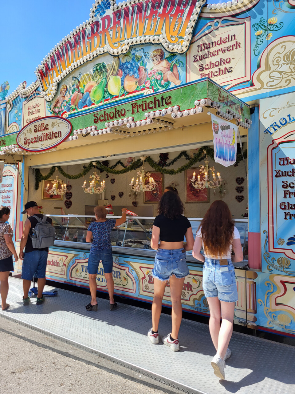Menschen stehen vor einem Markt-Stand mit Schoko-Früchten und anderen Süßigkeiten | © Stadt Geretsried