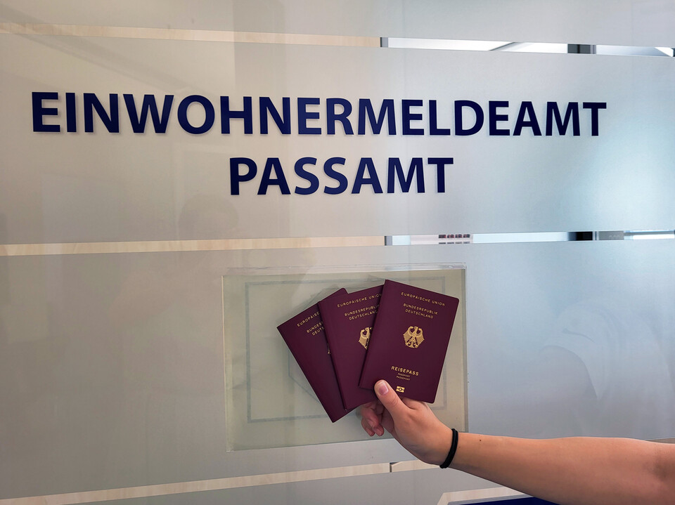 Eine Person hält 3 Reisepässe in der Hand vor der Tür des Passamtes | © Stadt Geretsried